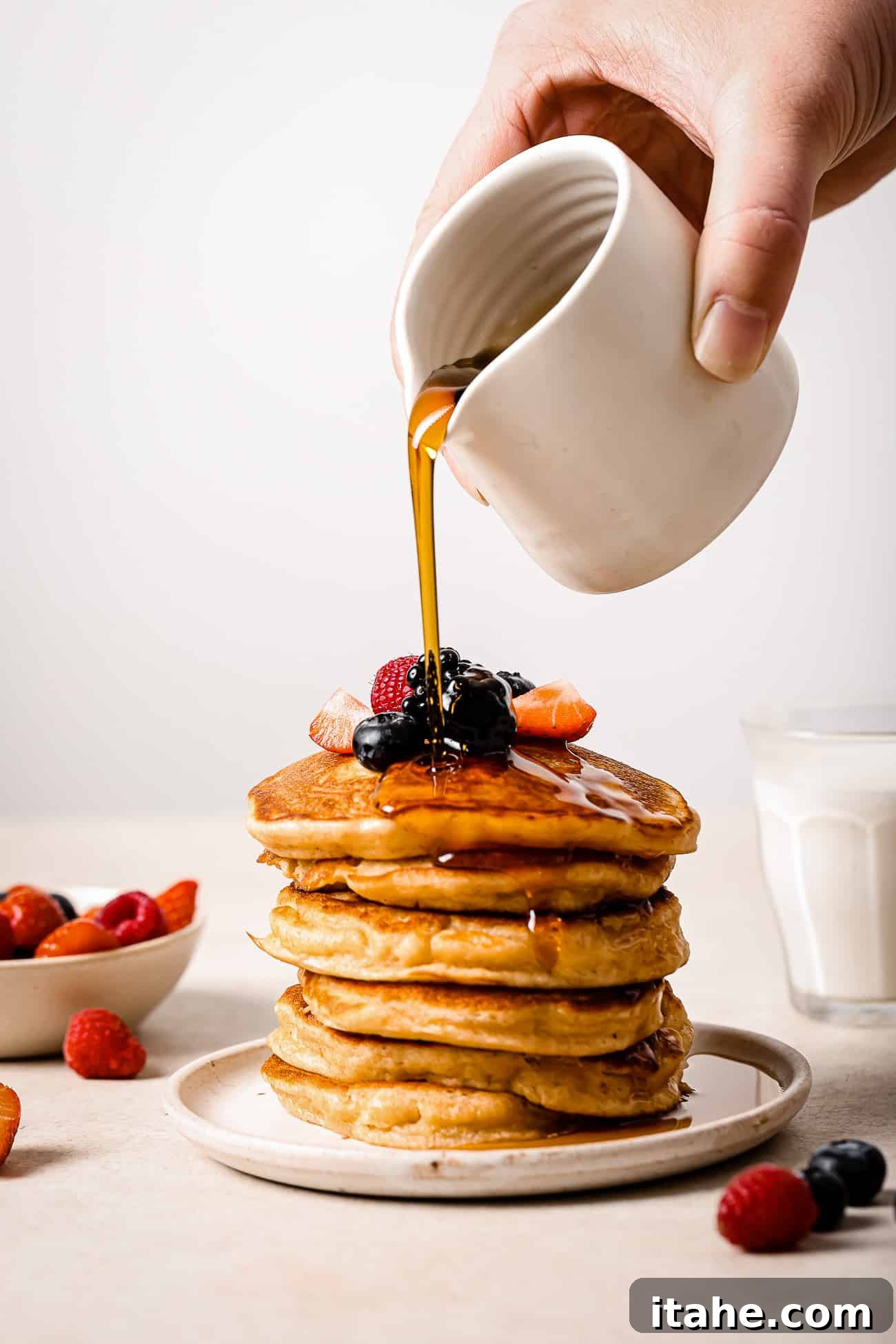 Creamy Peanut Butter Flapjacks 2 Stack of peanut butter pancakes topped with syrup and berries on a white plate