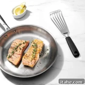 overhead view of a fish fillet inside of a skillet and a spatula beside the skillet