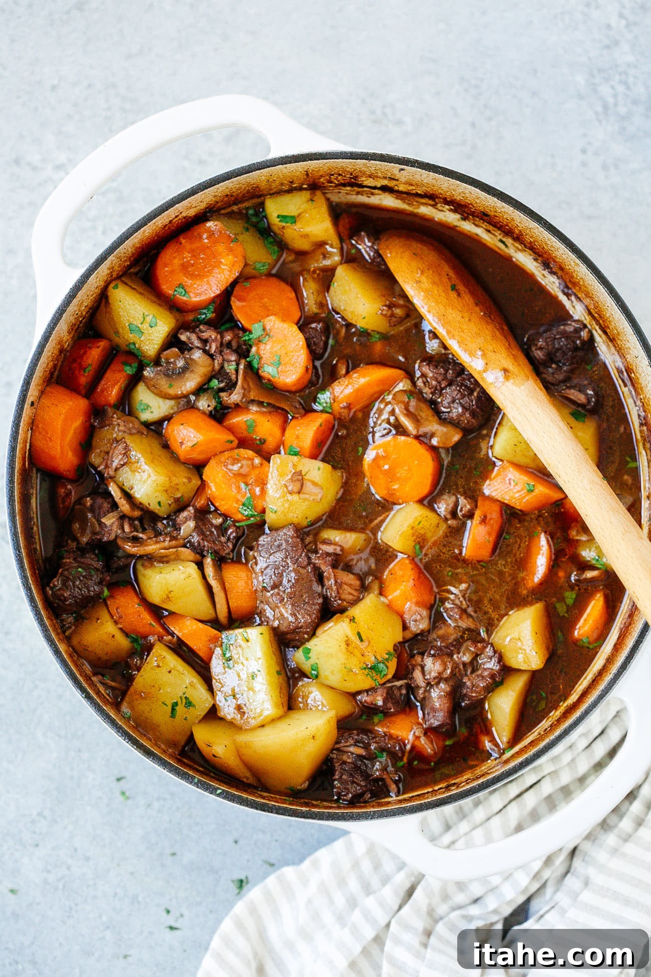 Overhead view of a Dutch oven filled with a perfectly cooked, rich beef stew, ready to be served.