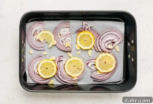 baking sheet with slices of red onions and lemon
