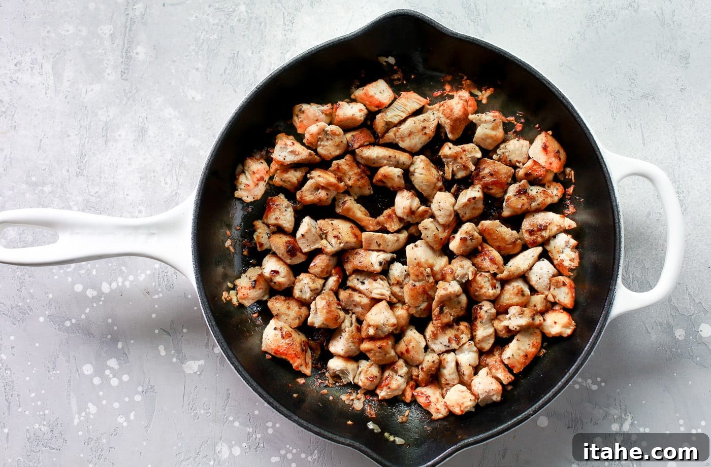 Golden Chicken Sweet Potato Bake 3 Pieces of chicken cooking in a skillet, turning golden brown.