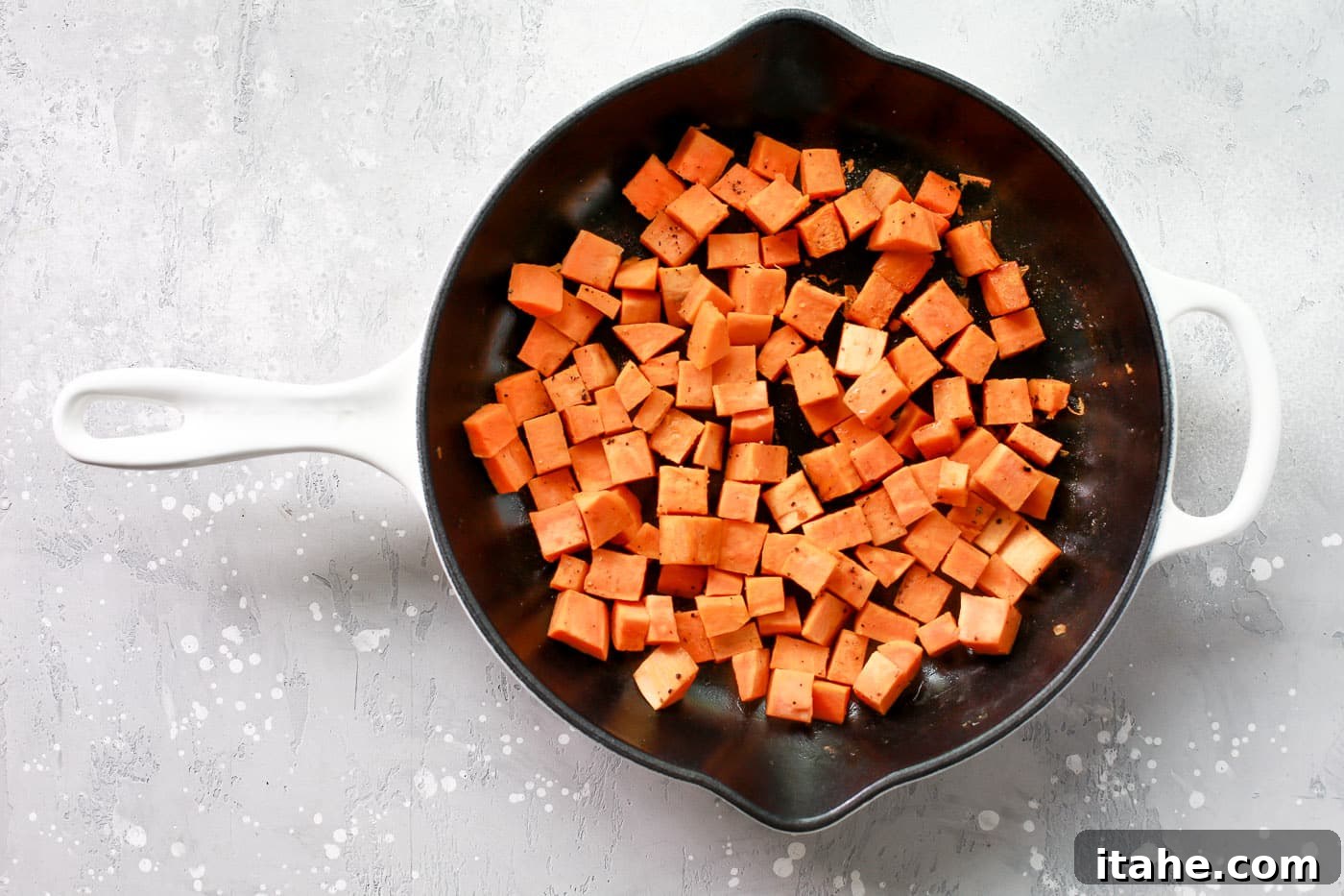 Golden Chicken Sweet Potato Bake 4 Diced sweet potatoes simmering in chicken broth in a skillet, covered with a lid.