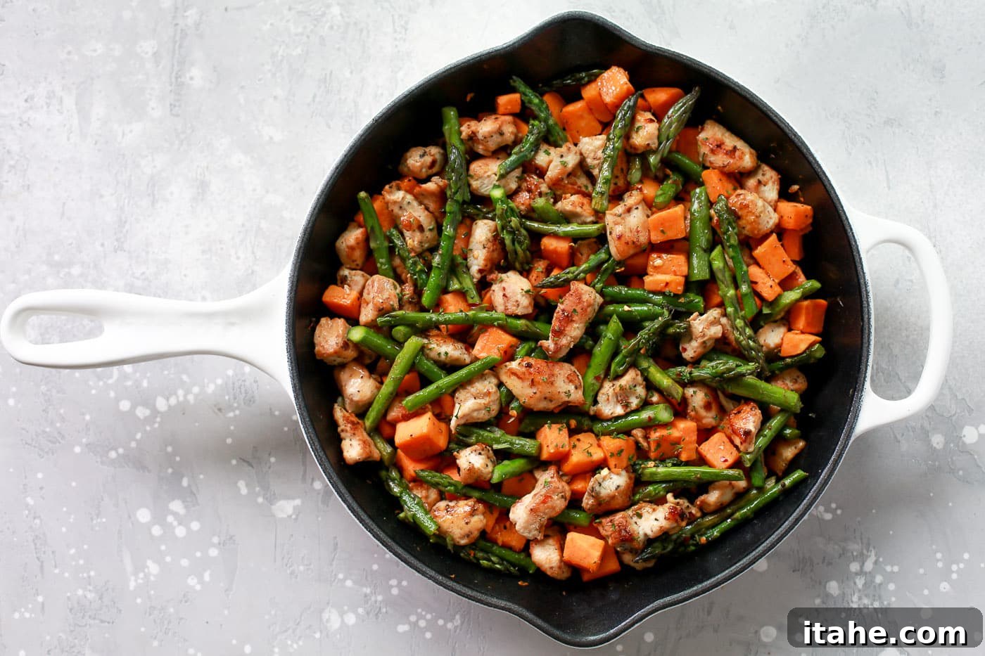 Golden Chicken Sweet Potato Bake 5 Chicken, sweet potatoes, and asparagus cooking together in a single skillet.