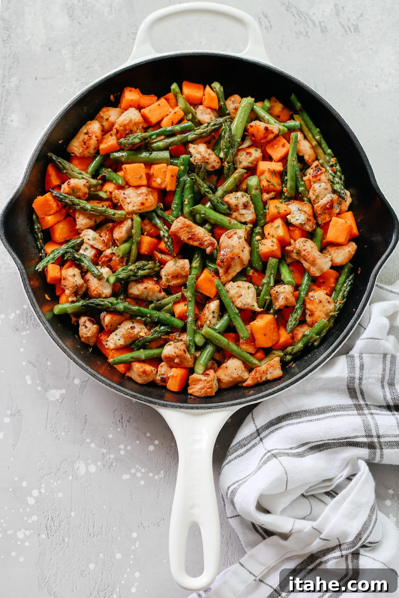 Golden Chicken Sweet Potato Bake 7 A vibrant platter of Asparagus Sweet Potato Chicken Skillet from Primavera Kitchen, ready for serving or meal prep.