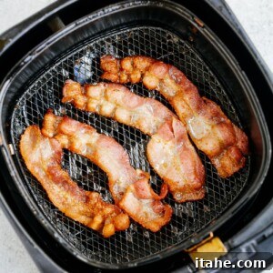 overhead view of cooked bacon inside of a air fryer basket