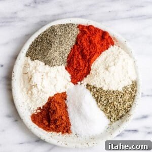 A collection of spices arranged in a plate, showcasing the vibrant ingredients of Cajun seasoning.