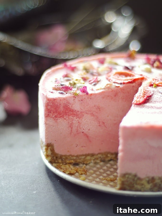 A stunning strawberry lime macadamia cheesecake on a serving plate, with a perfect slice removed to showcase its layers.