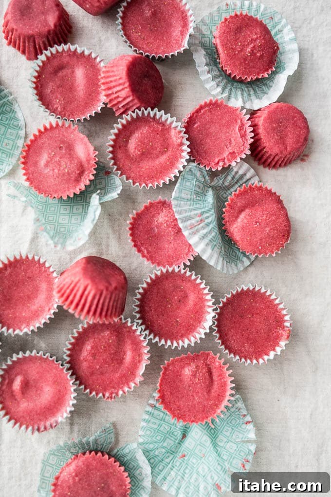 An inviting overhead view of several beautiful strawberry coconut butter cups arranged against a clean white background.