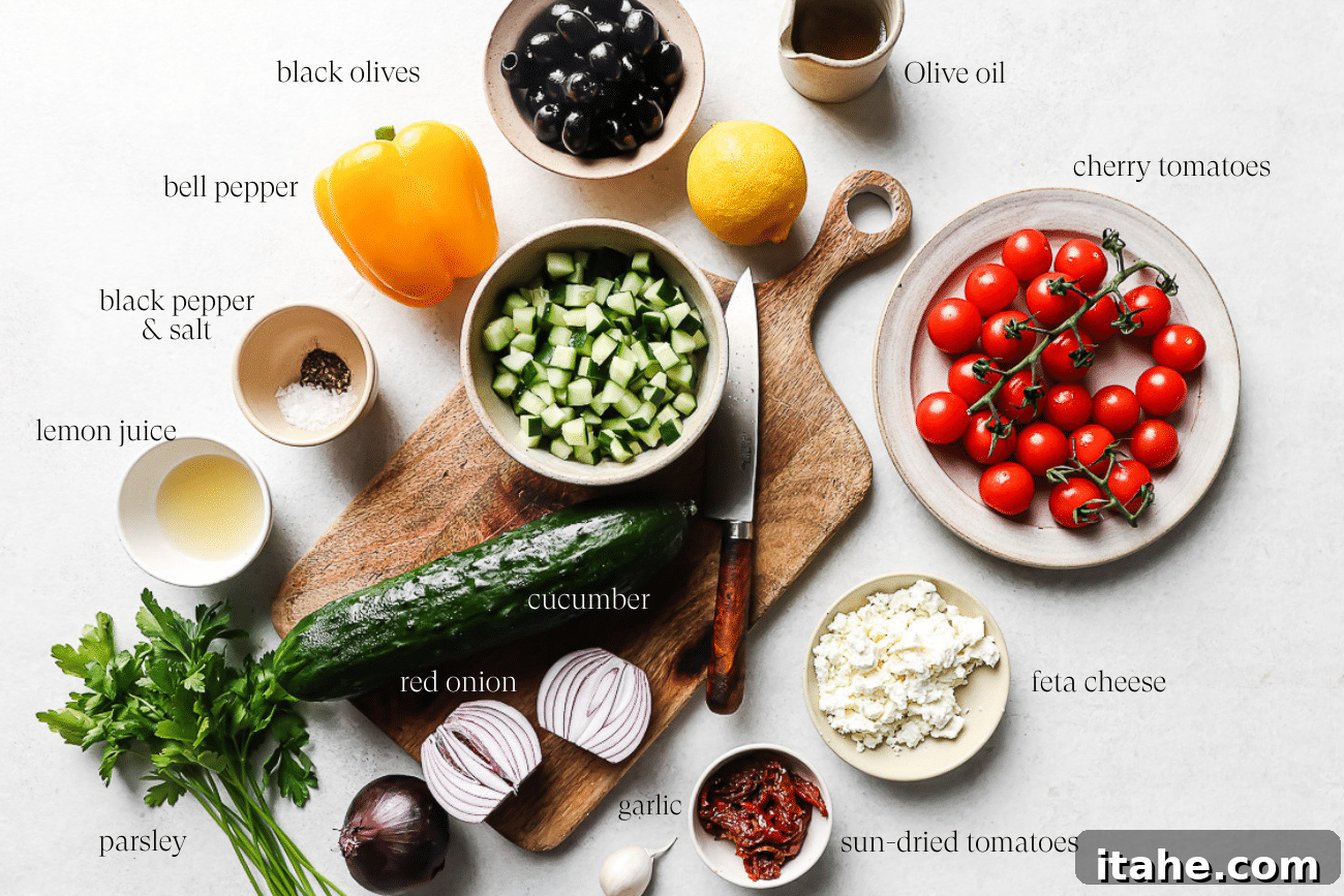 An overhead view showcasing all the fresh, colorful ingredients laid out before assembly, including cherry tomatoes, bell peppers, cucumber, feta, olives, and herbs, ready to be combined for a Mediterranean Salad.