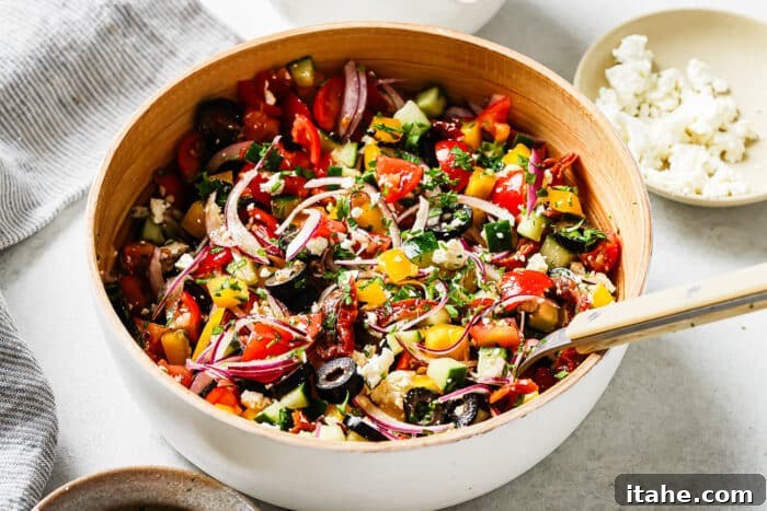 The vibrant Mediterranean Salad, fully dressed and tossed, presented in a clean white serving bowl, ready to be enjoyed.