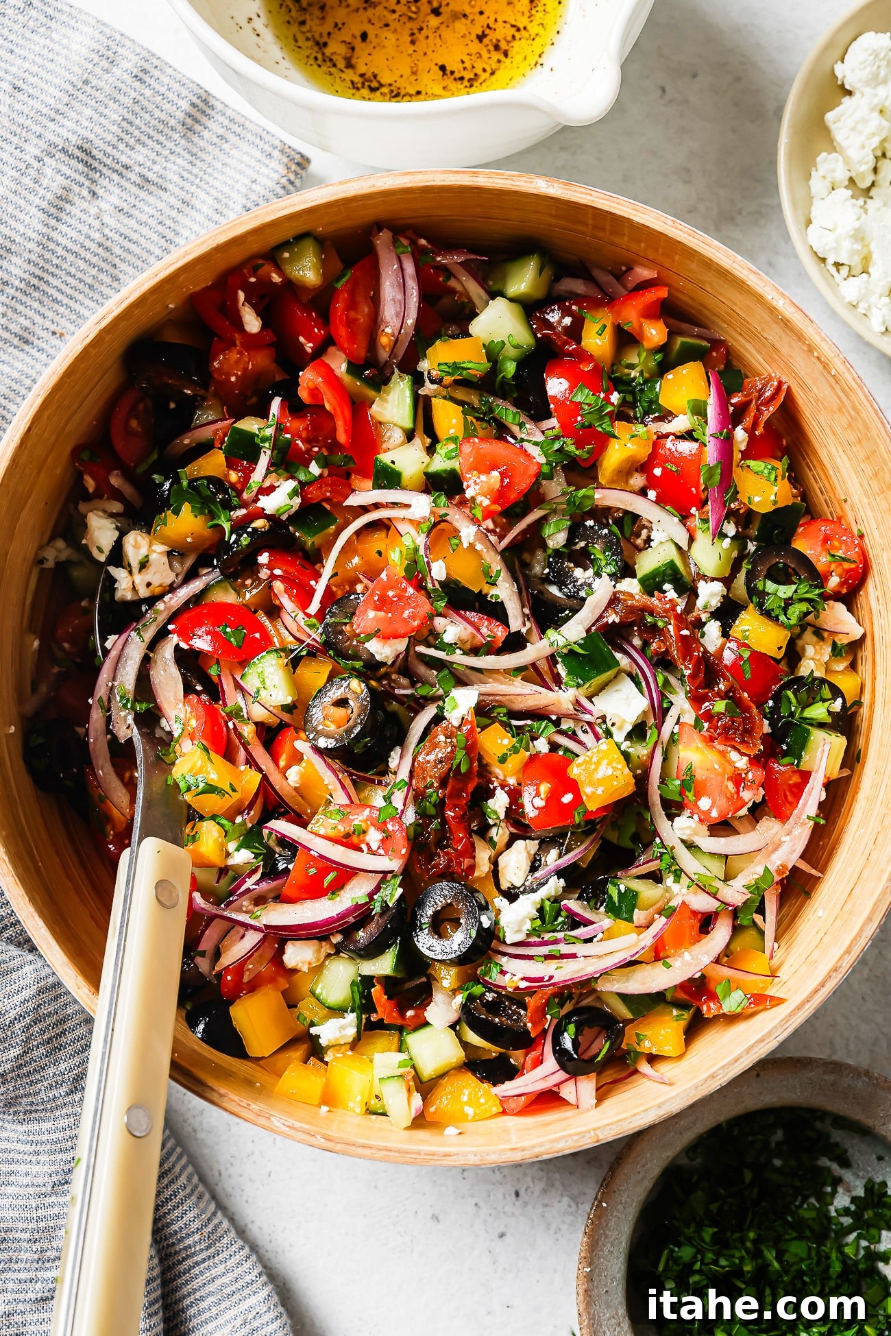 A vibrant Mediterranean Salad in a clean white bowl, captured from an overhead angle, showcasing its fresh ingredients, with a rustic wooden background.
