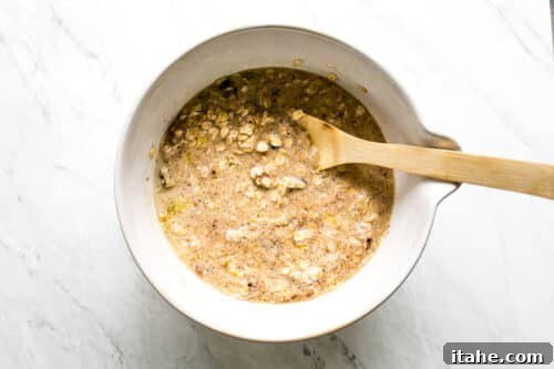 Wet and dry ingredients combined in a large bowl to form baked oatmeal batter.
