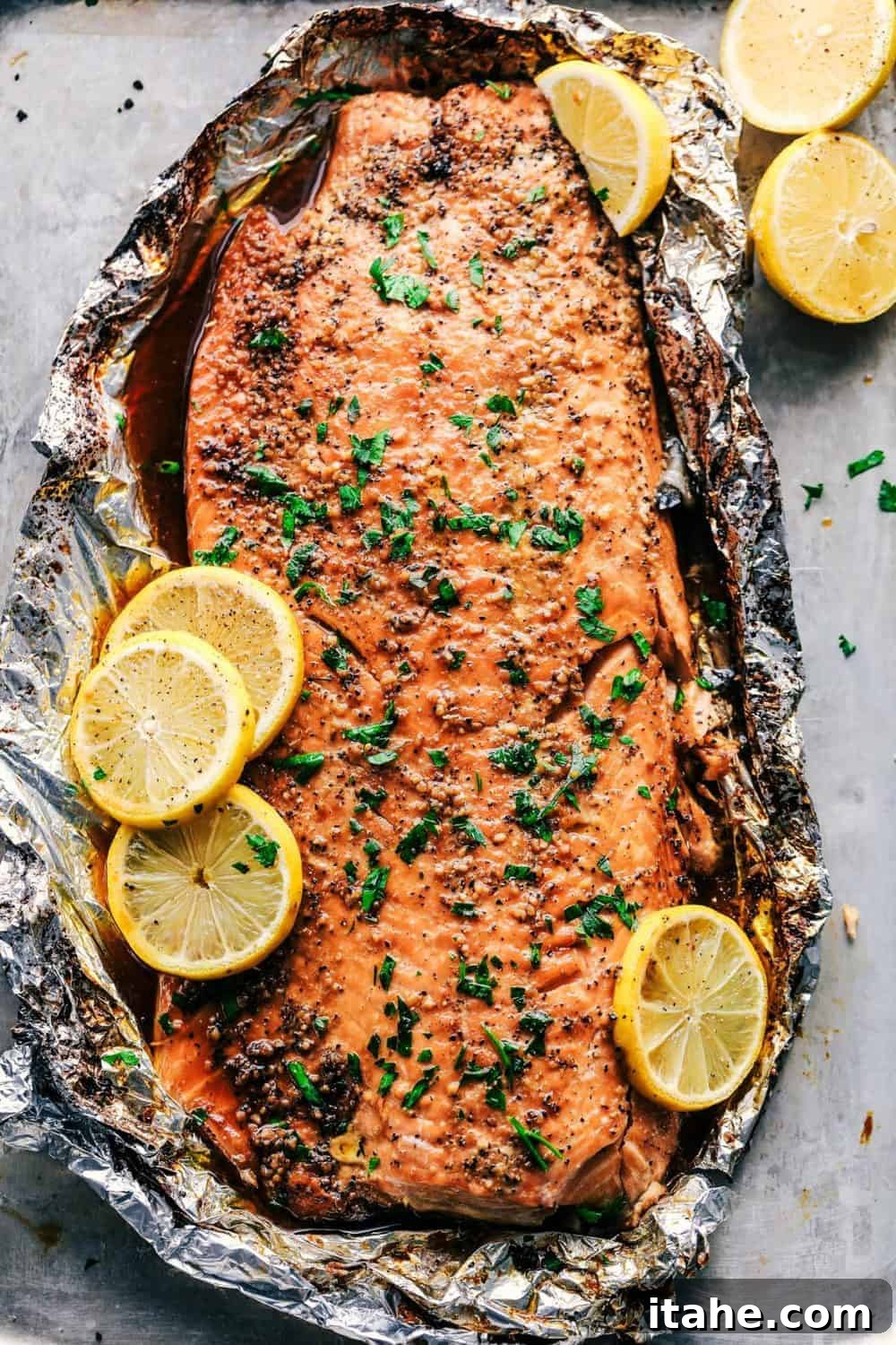An overhead view of a beautifully glazed salmon fillet, with garlic and brown sugar, on a baking sheet.