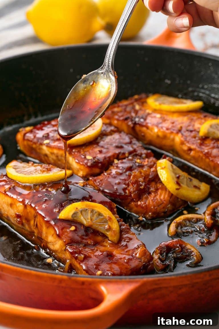 An overhead view of a cast iron skillet filled with beautifully glazed honey garlic salmon.