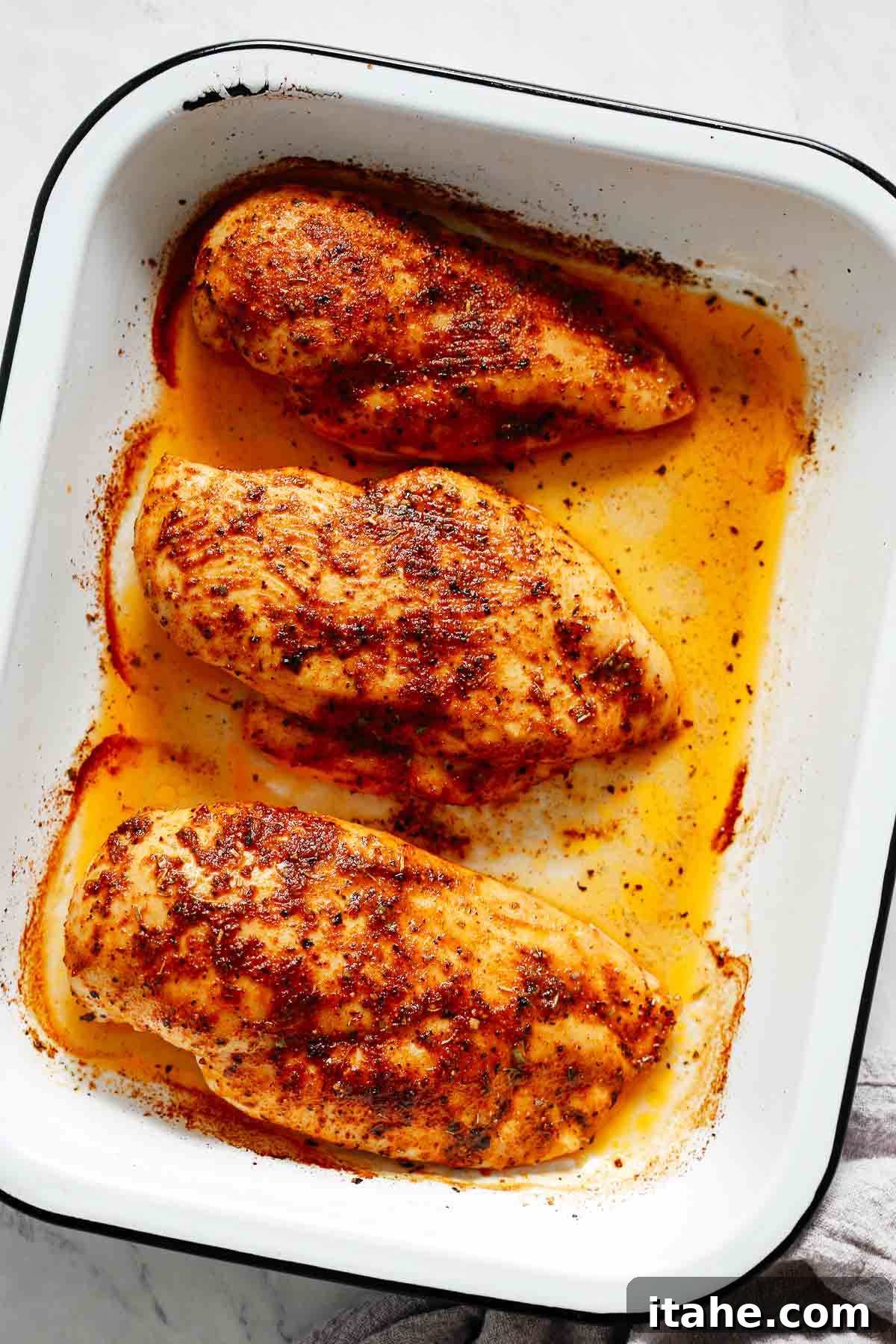 Juicy Oven Baked Chicken Breast 6 Golden brown baked chicken breasts in a white casserole dish, fresh out of the oven