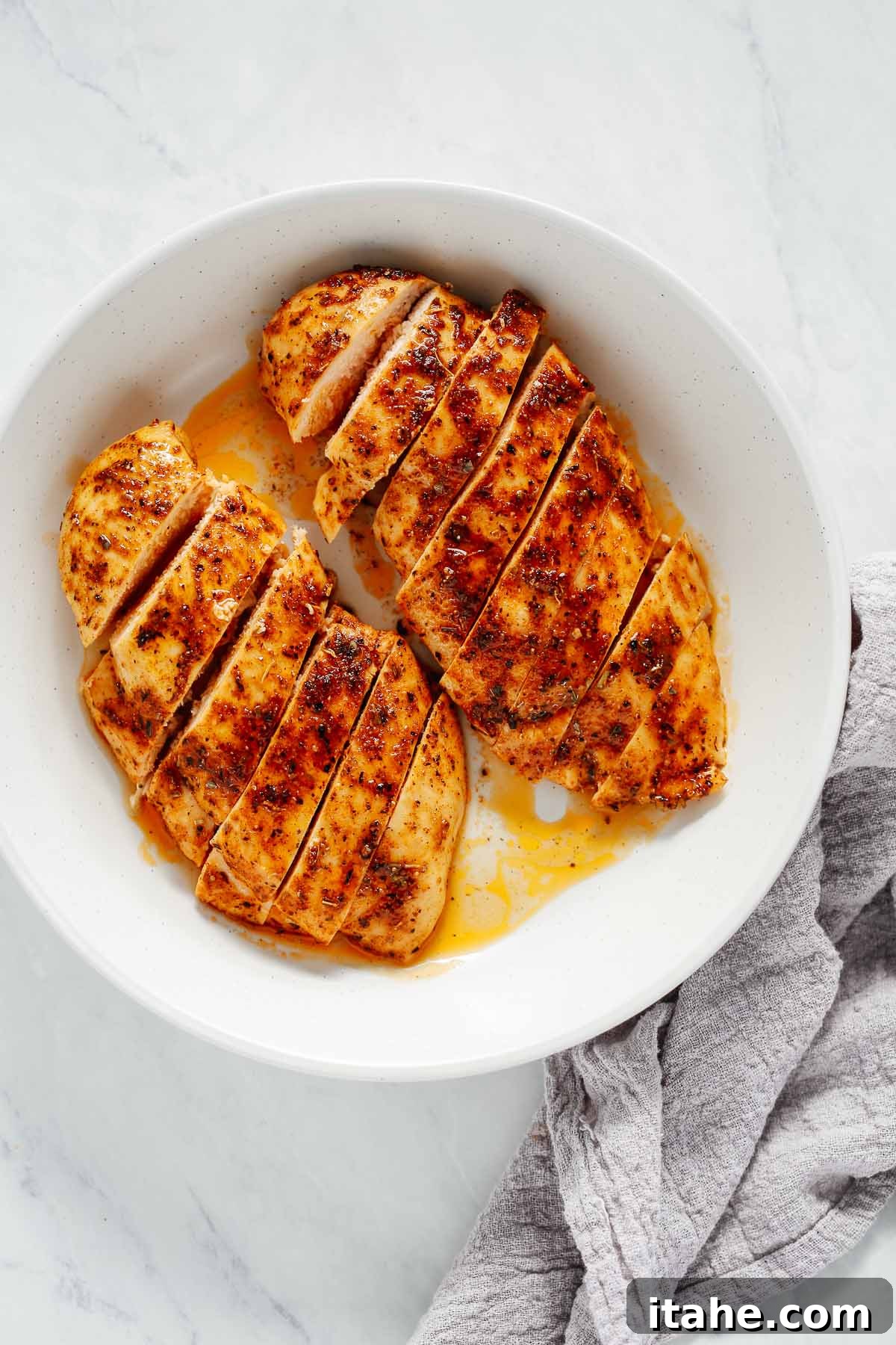Juicy Oven Baked Chicken Breast 7 Beautifully sliced seasoned chicken breast on a white plate, ready to serve