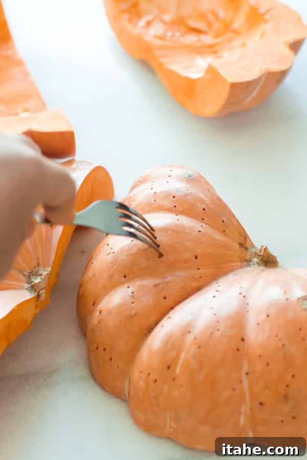 Pumpkin Wedges Ready for Roasting Pumpkin wedges pierced with a fork arranged on a baking sheet