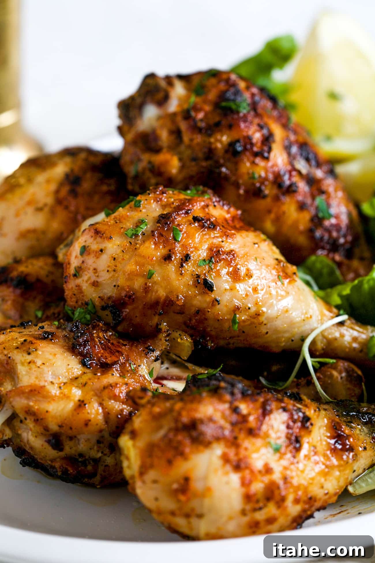 Perfectly Charred Chicken Legs 6 A generous serving of grilled chicken wings, perfectly charred and seasoned, arranged appealingly on a white plate, invitingly ready to eat.
