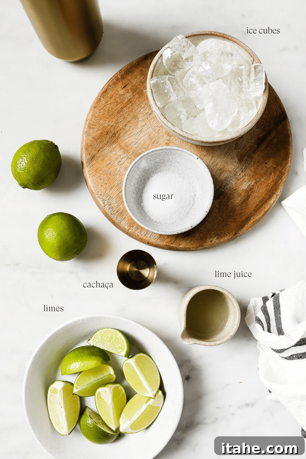Caipirinha A Brazilian Classic 3 Pre-measured ingredients laid out neatly for making a Caipirinha: cachaça, limes, and sugar.