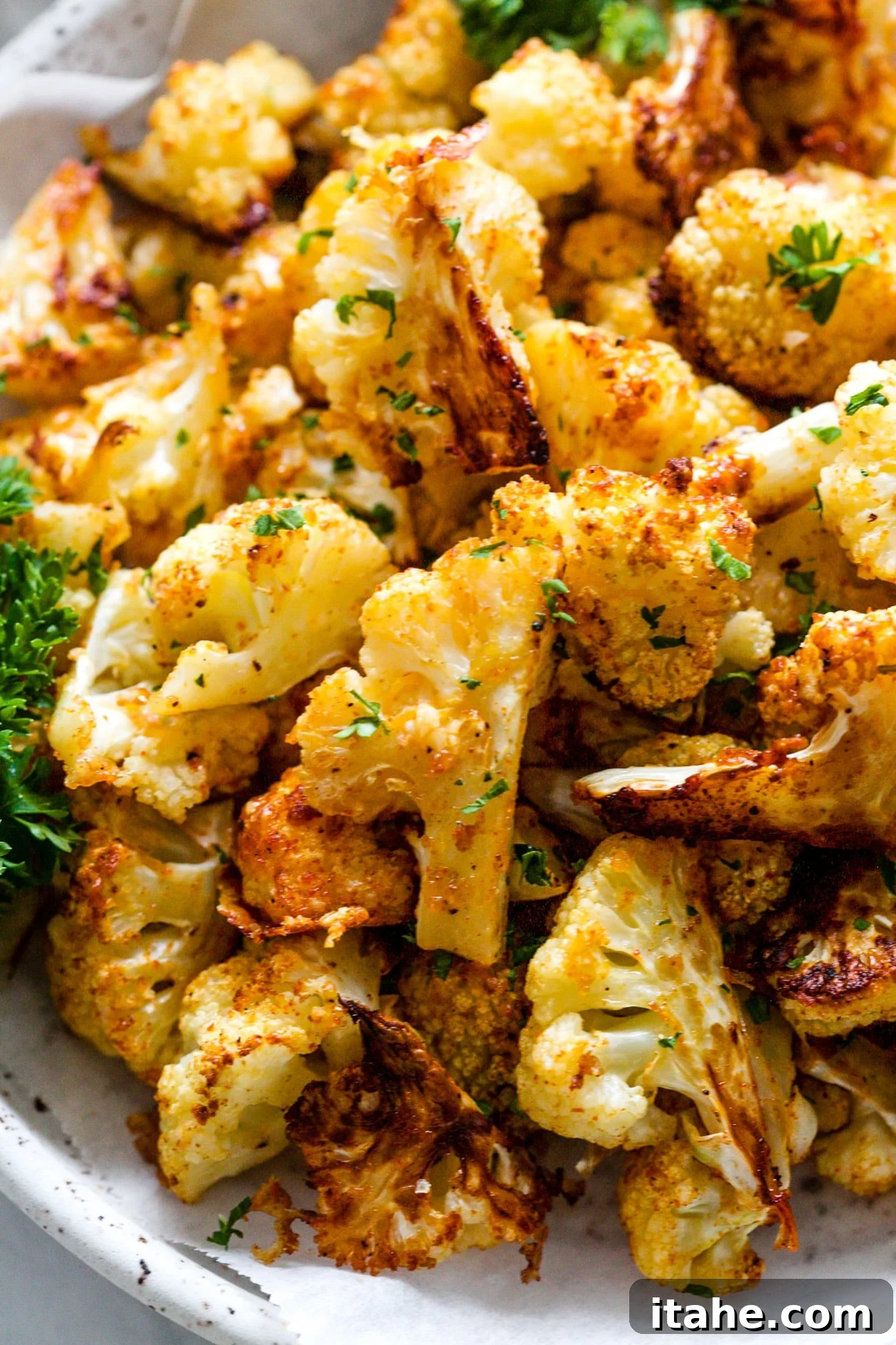 Crispy Cauliflower Poppers 6 Close-up view of a serving of crispy, golden cauliflower bites, garnished with fresh parsley.