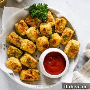 An overhead shot of a generous serving of crispy, golden cauliflower tots on a white plate, ready to be enjoyed as a healthy snack or side.