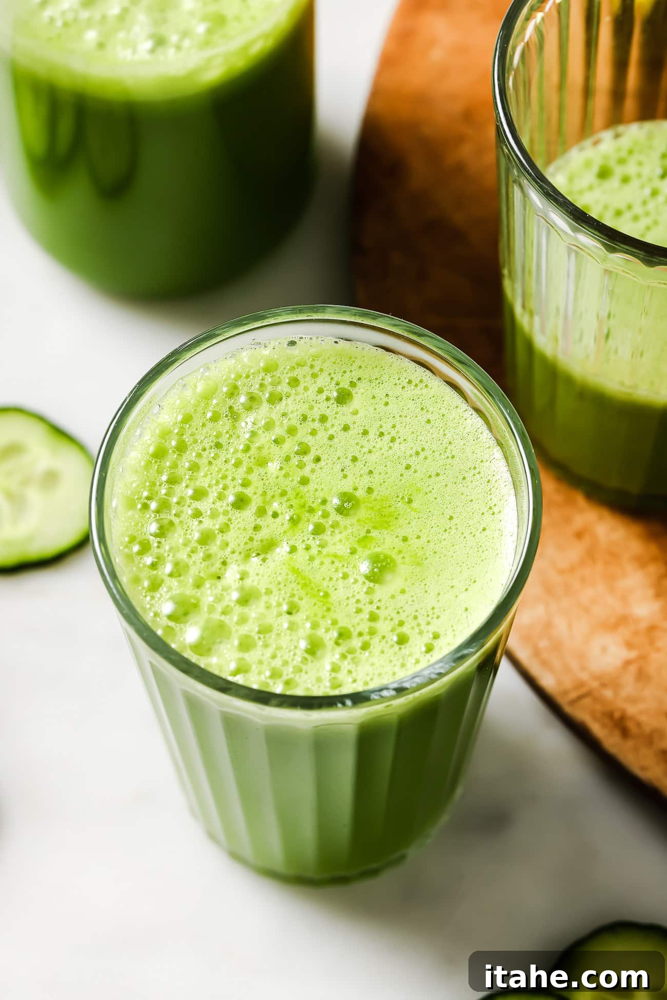 An inviting overhead view of a single glass of green juice, possibly with a subtle garnish, presented on a clean surface, emphasizing its freshness and appeal.