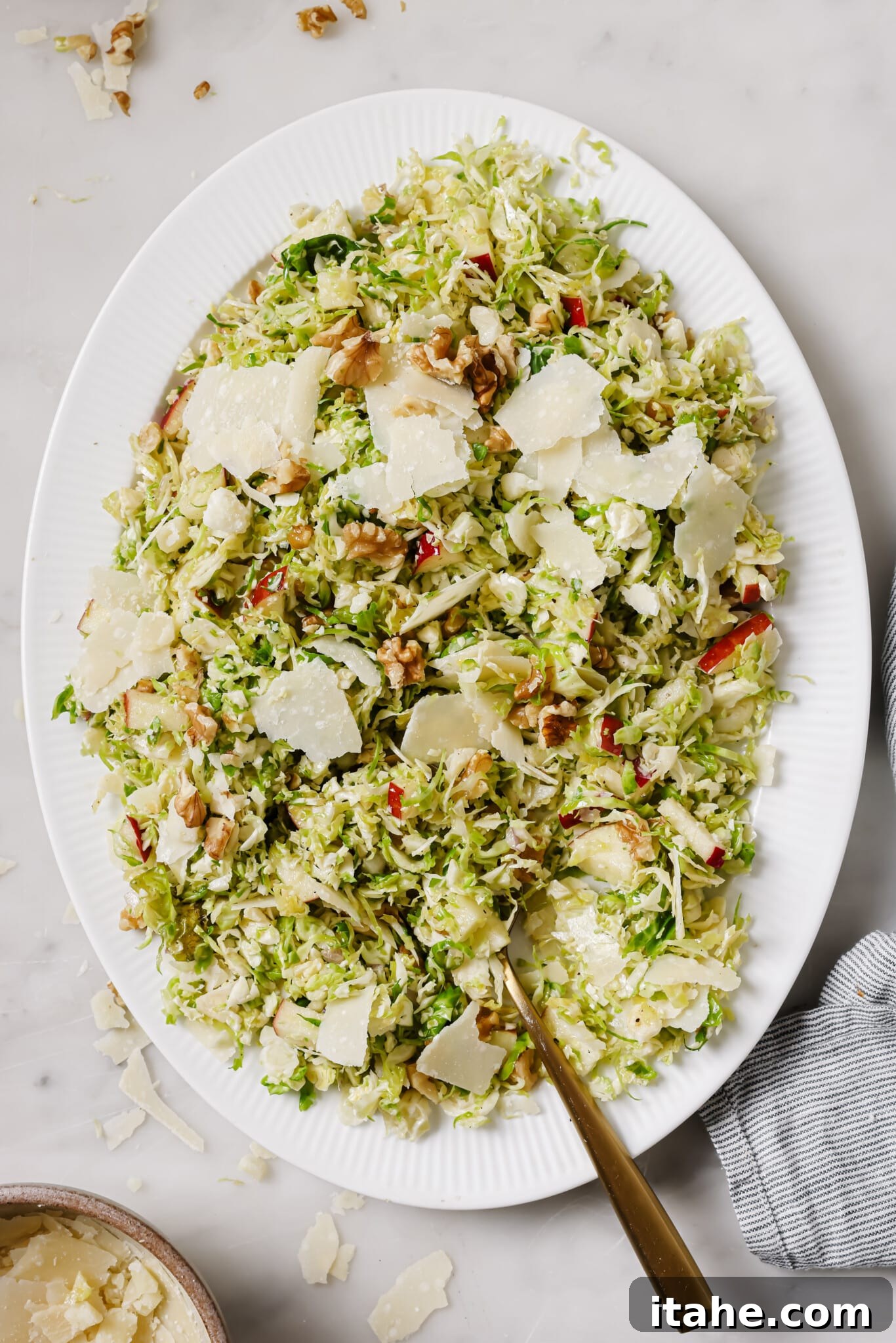 Finished Shaved Brussels Sprouts Salad on a white serving platter, ready to eat.