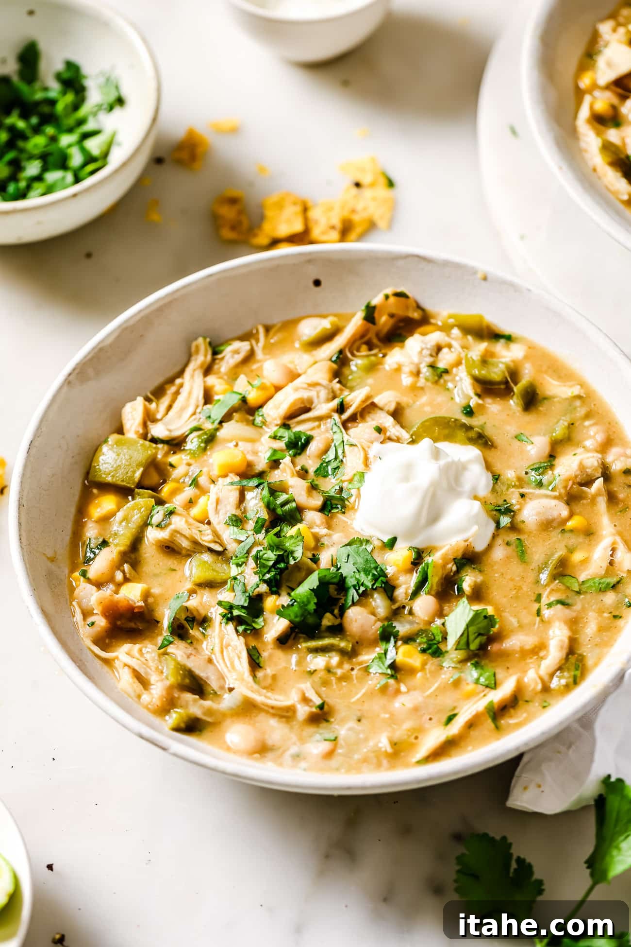 A bowl of creamy White Chicken Chili garnished with fresh cilantro and a dollop of sour cream, ready to be enjoyed.