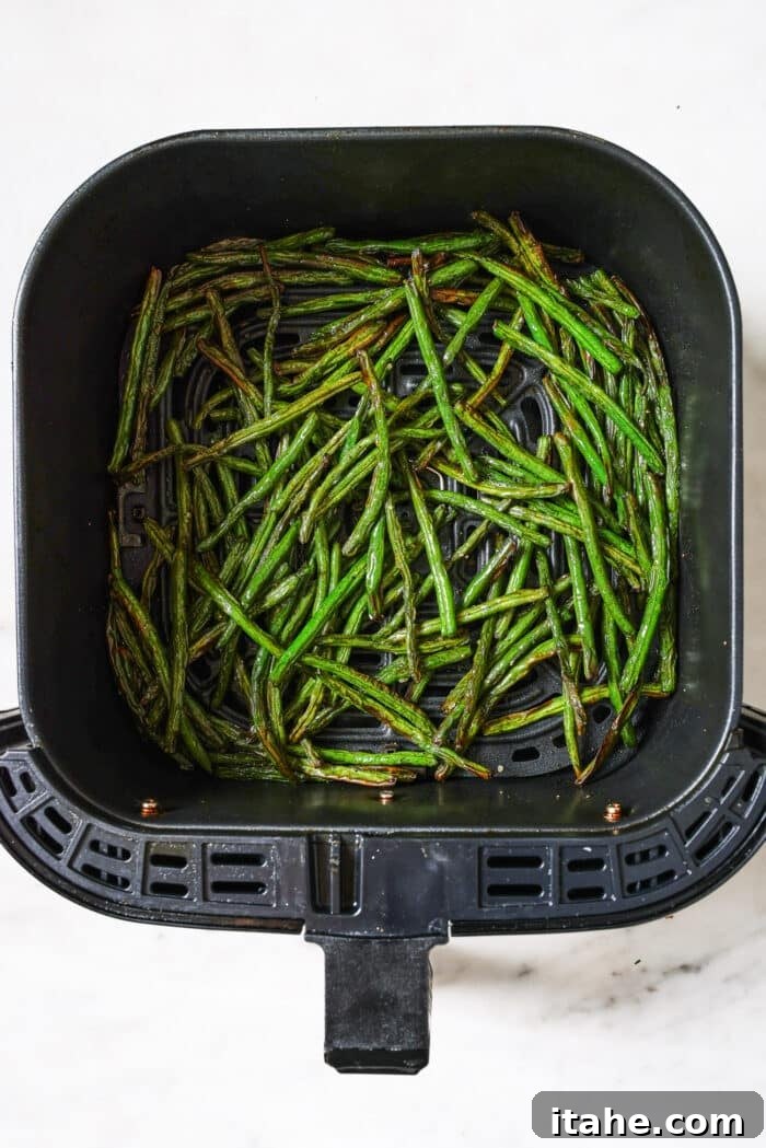 Perfectly Crispy Air Fryer Green Beans 6 Air frying green beans shaking halfway through the cooking process.