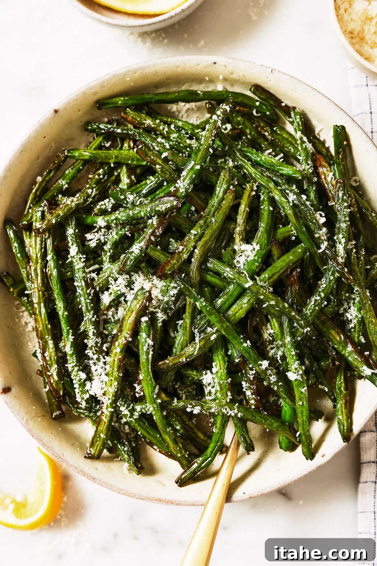 Perfectly Crispy Air Fryer Green Beans 9 A bowl of air fryer green beans with parmesan cheese on top, ready to be enjoyed.