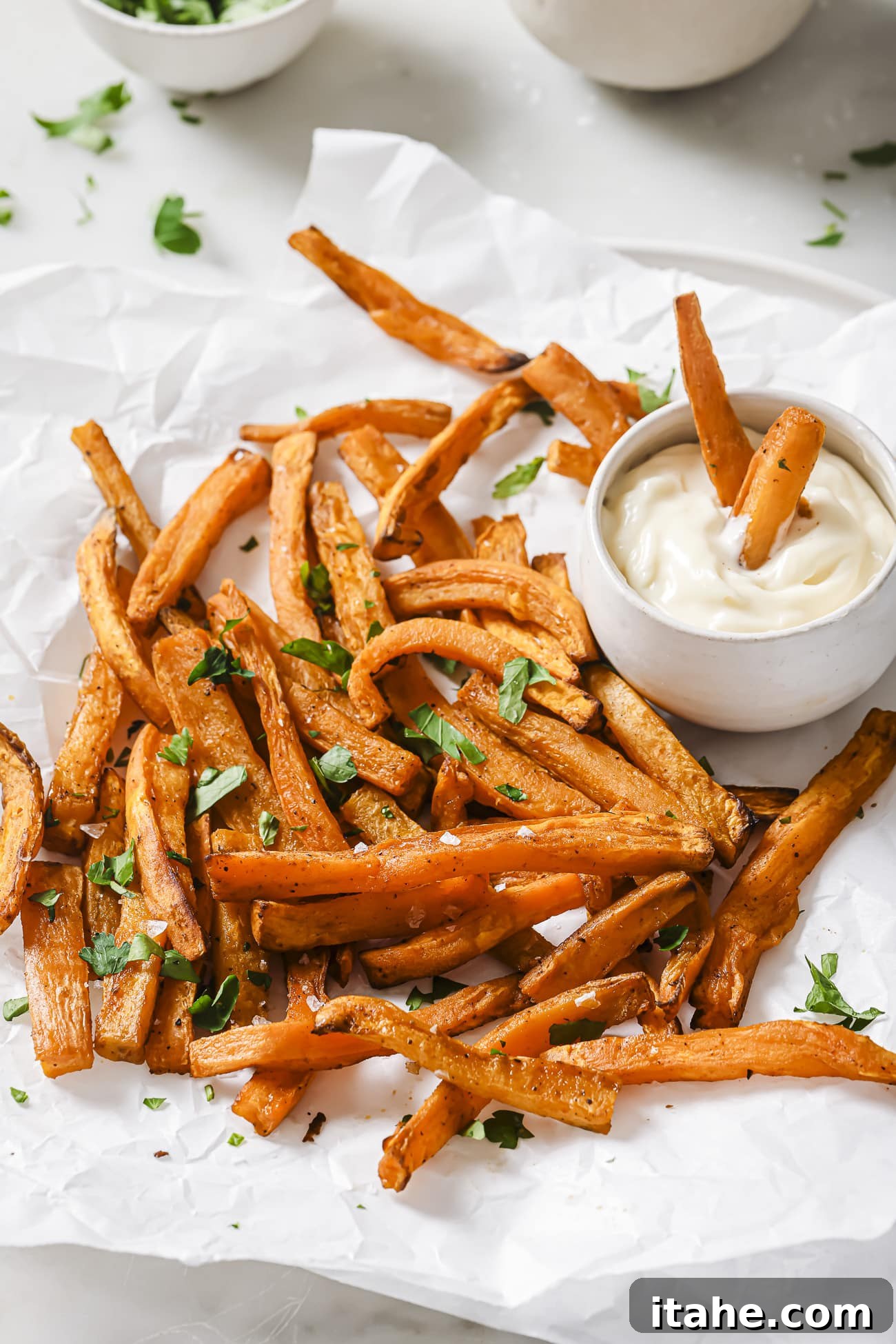 Perfectly Crispy Air Fryer Sweet Potato Fries 2 Air fryer sweet potatoes with dipping sauce on the side.