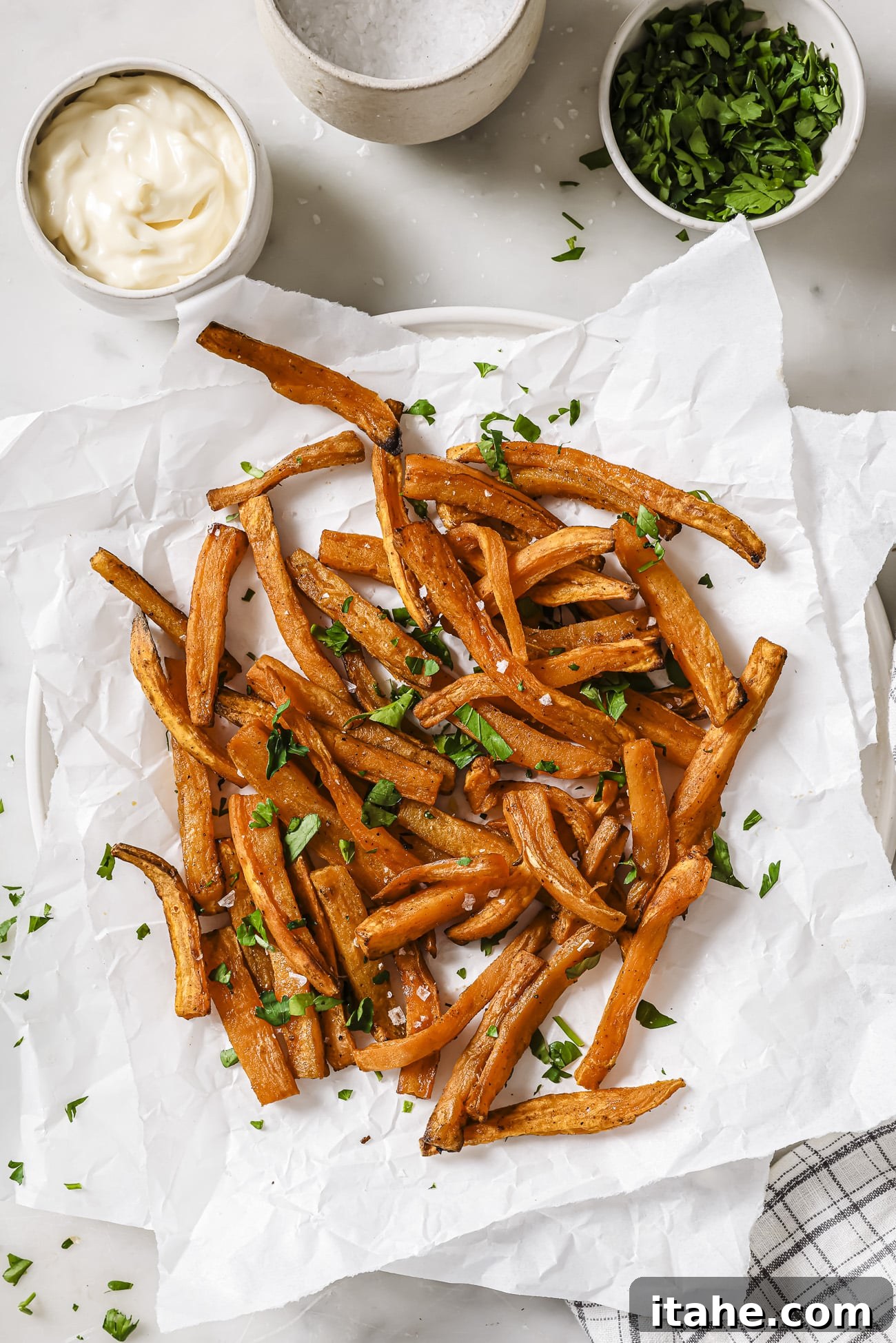 Perfectly Crispy Air Fryer Sweet Potato Fries 7 Air fryer sweet potatoes with garnish and dipping sauce on the side.