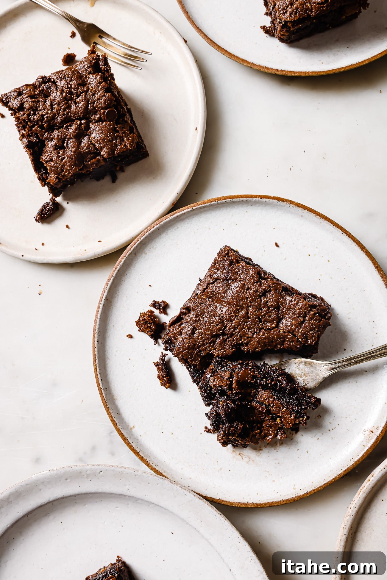 A square piece of flourless brownies on a white plate. 
