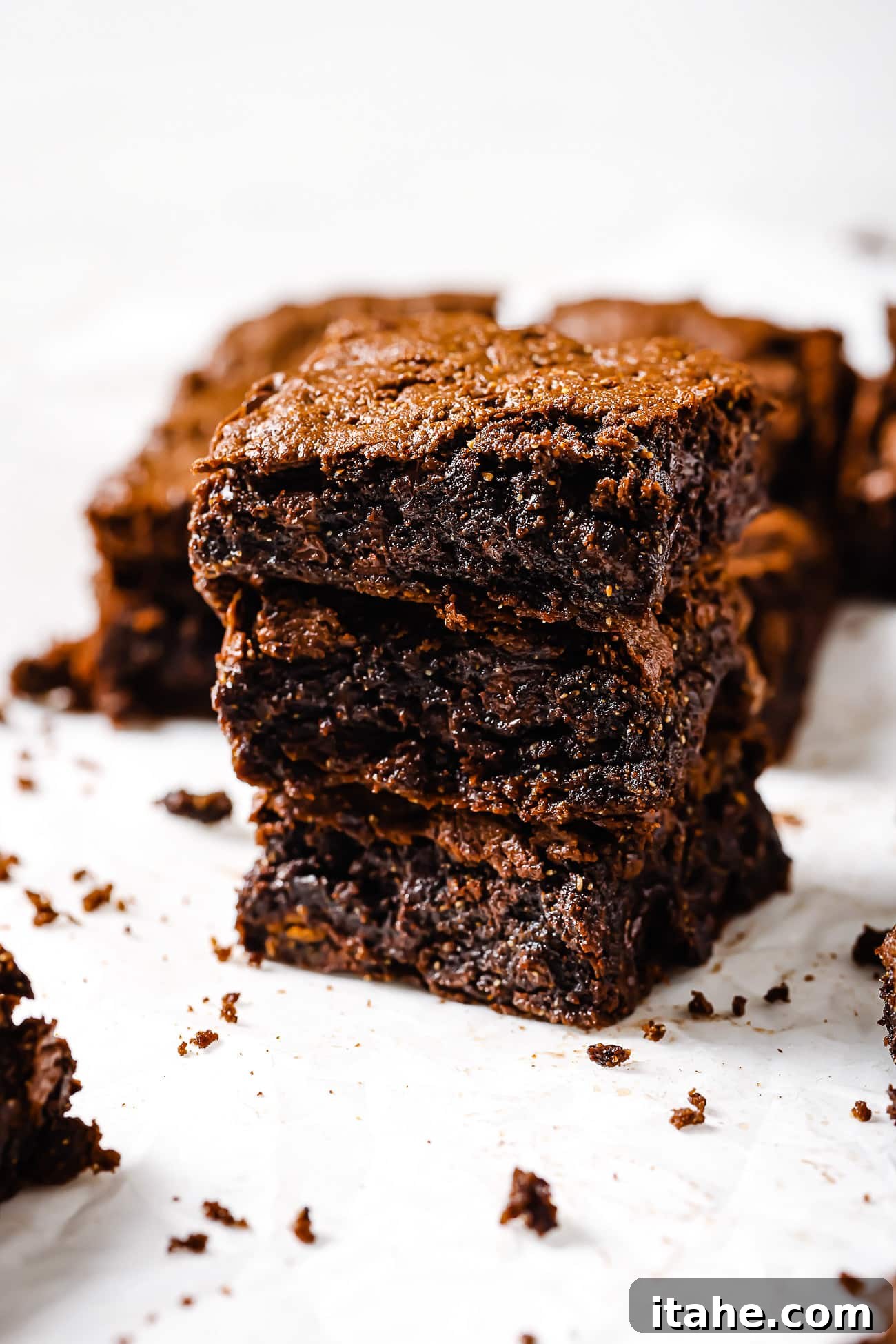 Three square-cut pieces of flourless brownies stacked up. 