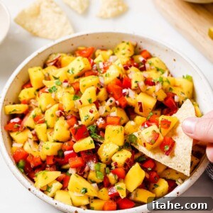 A bowl of fresh mango salsa with cilantro garnish.