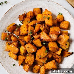A plate of golden, air-fried butternut squash, ready to be served as a healthy side dish.