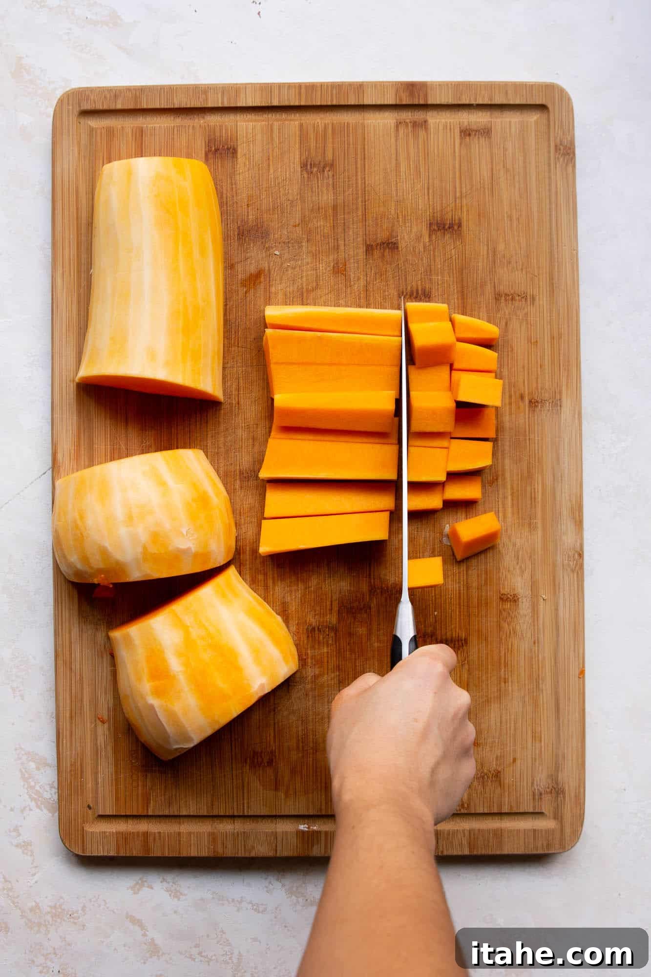 Lay the squash half on its flat side, and cut into three parts. The half ring portions will be harder to cut very evenly, but aiming for uniform thickness helps.