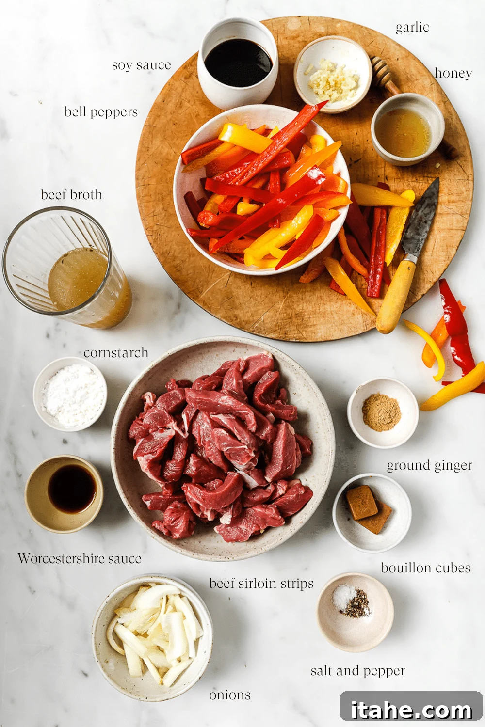 Slow Cooked Tender Pepper Steak 3 An overhead view of pre-measured key ingredients for slow cooker pepper steak on a white countertop.