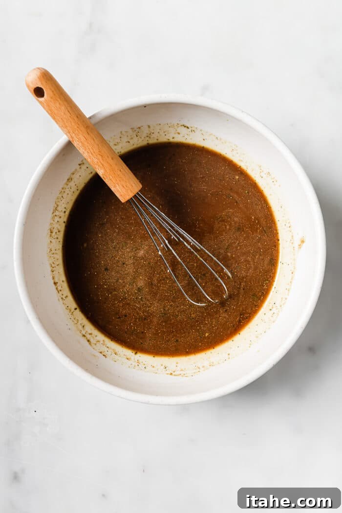 Slow Cooked Tender Pepper Steak 6 A small bowl of homemade pepper steak sauce with a whisk in it, ready to be added.