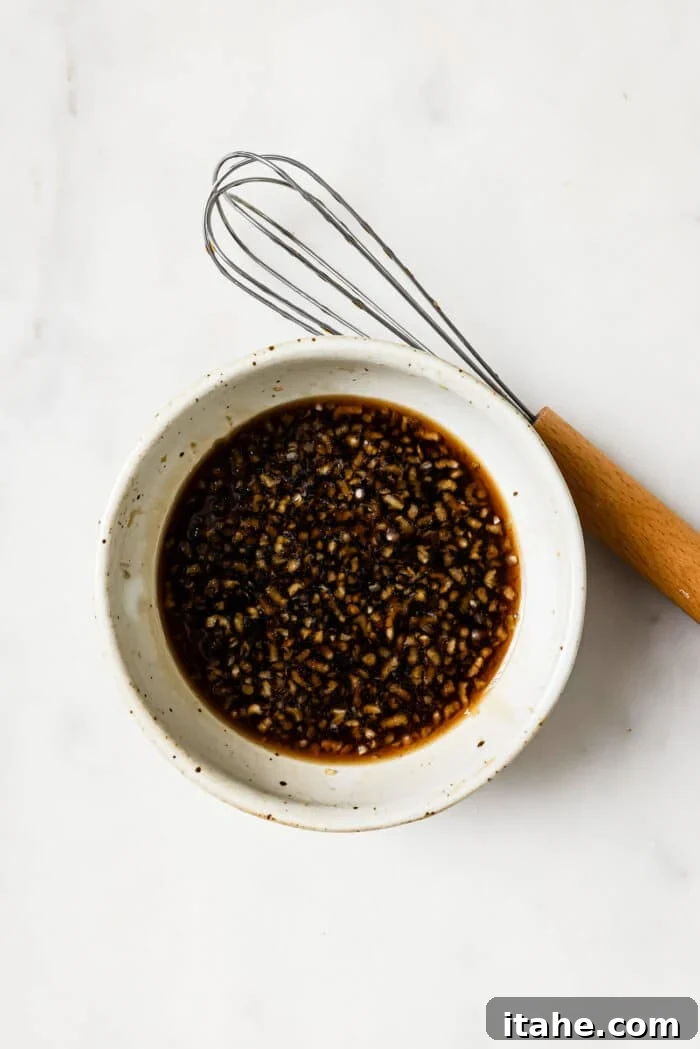 Garlic Honey Glazed Salmon 4 A small bowl of honey garlic sauce with a whisk on the side.