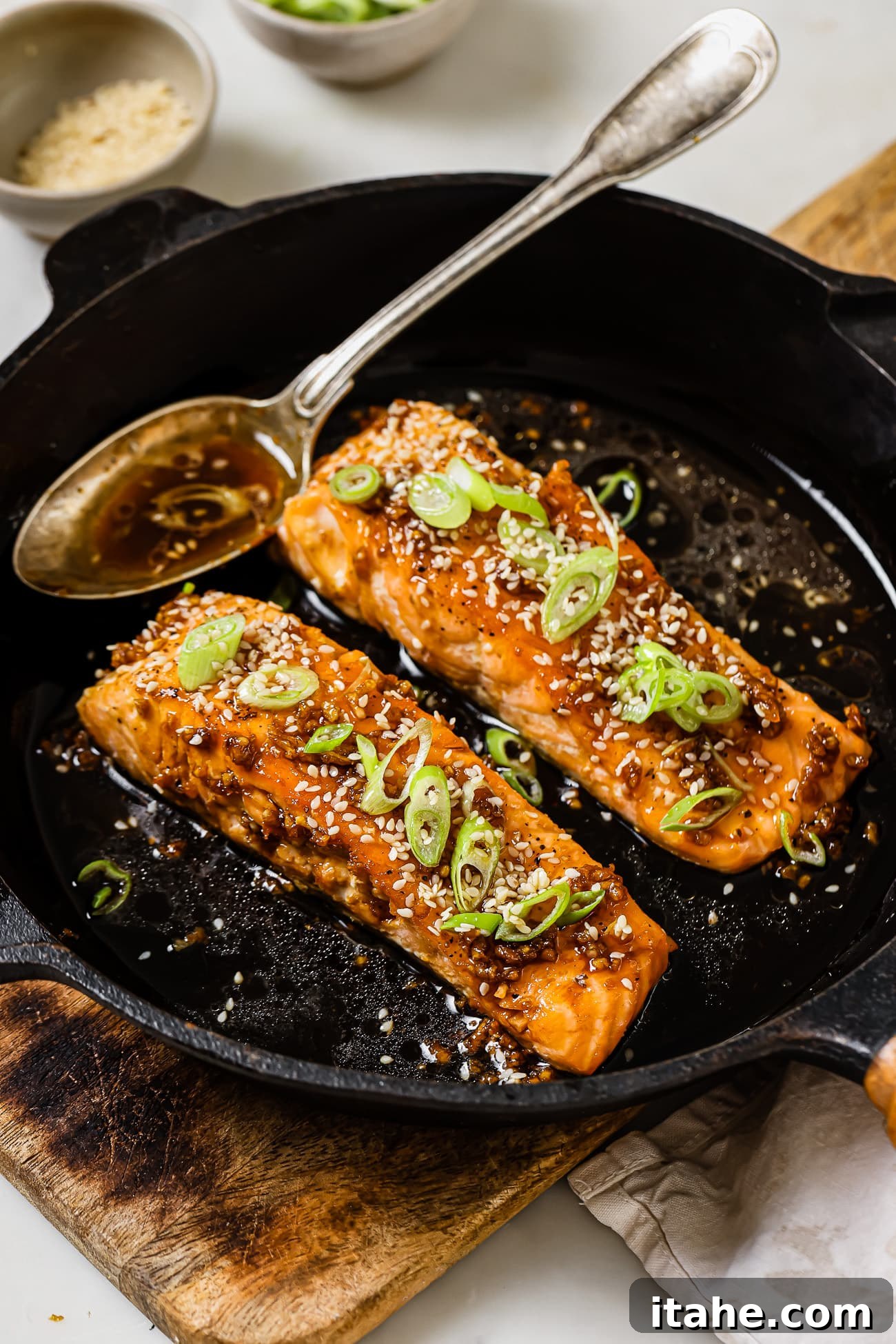Garlic Honey Glazed Salmon 8 Two honey garlic salmon fillets in a cast iron pan.