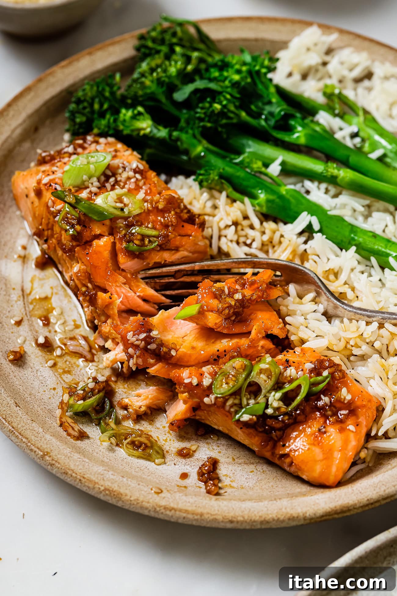 Garlic Honey Glazed Salmon 9 A honey garlic salmon fillet on a plate with rice and broccoli.