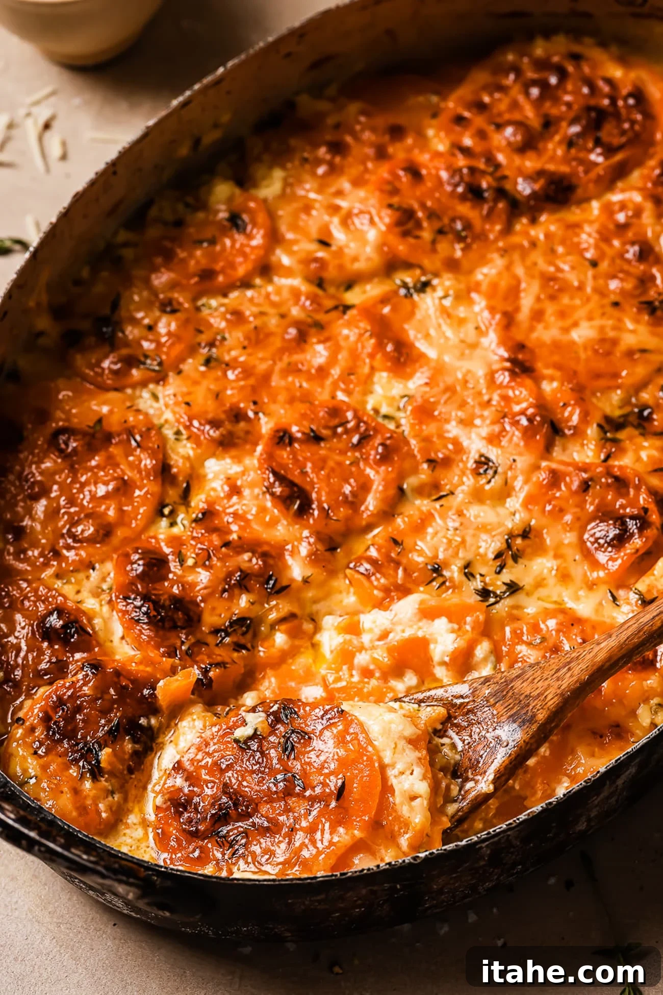 Sweet potato gratin in a baking dish with a spoon taking a serving out, highlighting its creamy texture.
