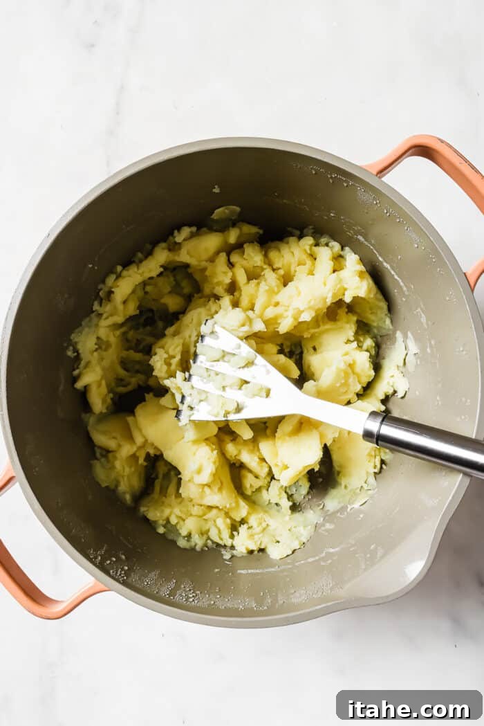 A large pot of mashed potatoes on a white countertop. 
