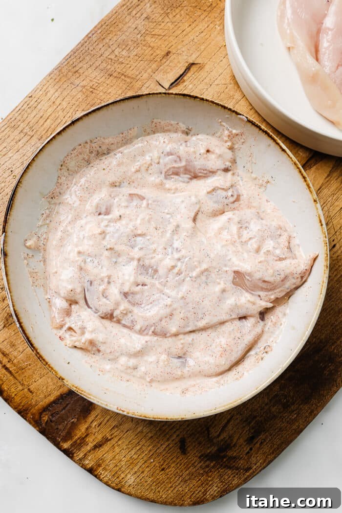 Creamy Yogurt Chicken Breasts 5 Chicken breasts coated in yogurt marinade arranged on a large serving plate.