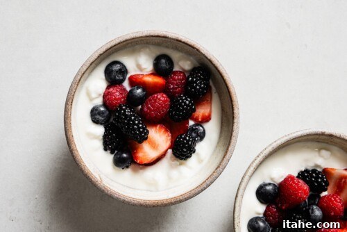 cottage cheese, yogurt, and a vibrant assortment of fresh berries layered in a bowl.