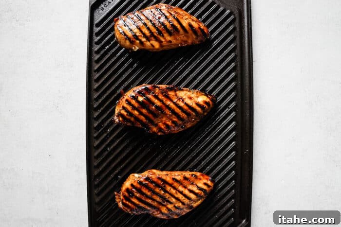 Sweet and Tangy Balsamic Chicken 6 Chicken breast cooking on a hot grill, showing grill marks.
