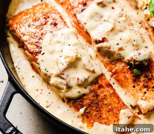 Seared salmon fillets returned to the skillet, submerged in the creamy Marry Me sauce.