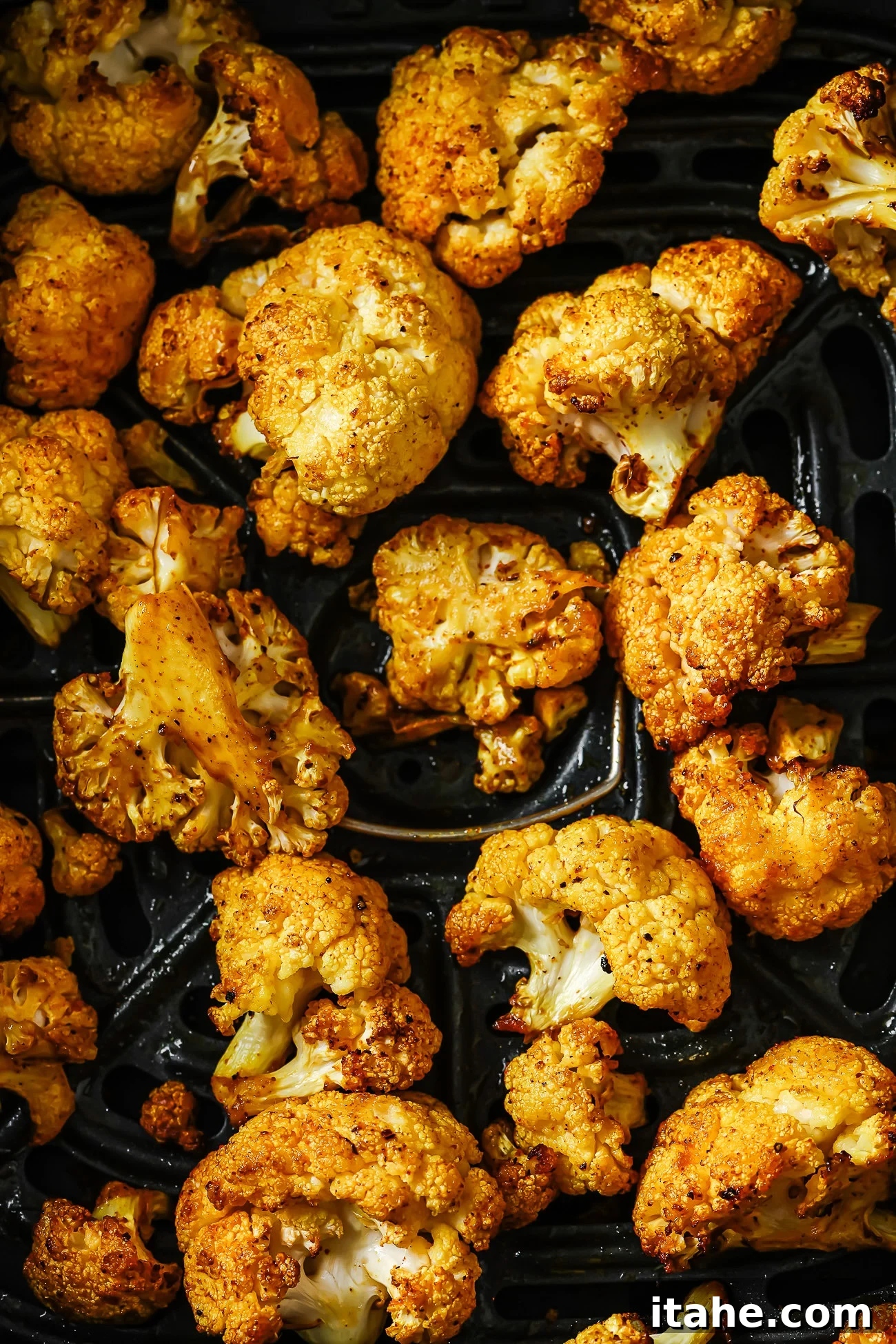 Crispy Roasted Air Fryer Cauliflower 11 Overhead view of seasoned and cooked crispy air-fried cauliflower florets in an air fryer basket, ready to serve.