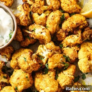 Overhead view of crispy air-fried cauliflower on a white plate, ready to be served.